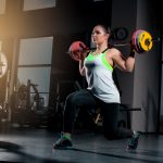 fit-young-woman-lifting-barbells-looking-focused-working-out-in-a-gym