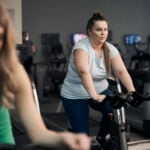 Overweight caucasian woman riding a bike at the gym
