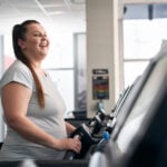 Plus size caucasian woman running on treadmill at gym