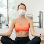 mulher-com-mascara-medica-fazendo-ioga-na-academia