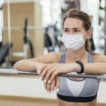 mulher-treinando-na-academia-durante-pandemia-com-mascara