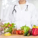 nutritionist showing healthy vegetables in the consultation.